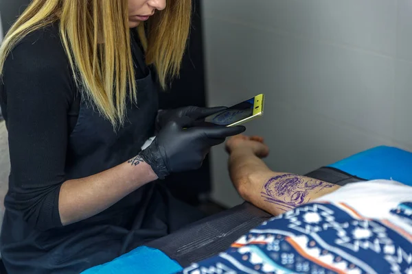 Bir dövme sanatçısı kız dövme fotoğraf çekmek üzere yapıyor — Stok fotoğraf