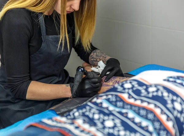 Egy tattooist szőke lány felhívja őt tetováló gép, a outl — Stock Fotó