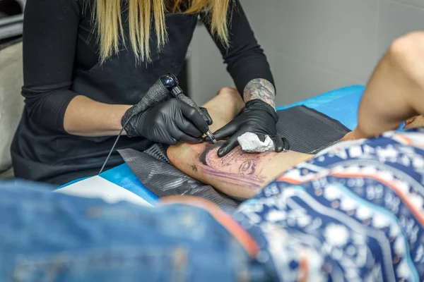 Blond meisje is de beeltenis van een tatoeage met haar tattoo machine — Stockfoto