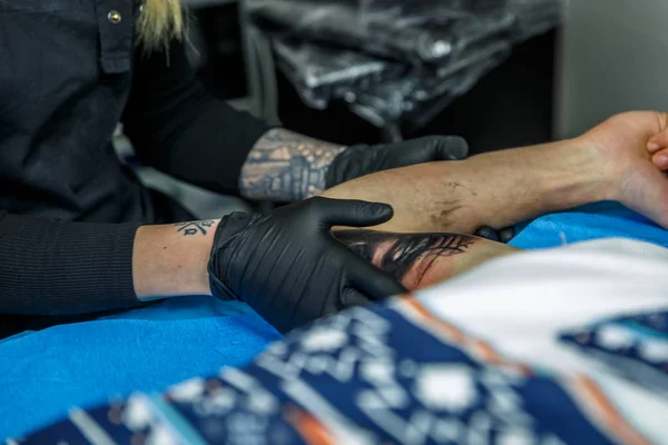 A artist girl revises the tattoo that she is doing — Stock Photo, Image