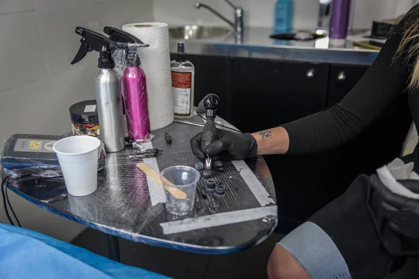 Mürekkep ve onu dövme makinesi bir sanatçı kadın düzeltir — Stok fotoğraf