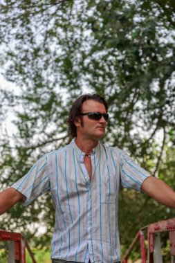 Çekici bir adam eski bir demir köprü üzerinde yürüyor