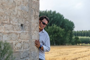 Doğanın ortasında eski bir evin arkasında bir olgun adam