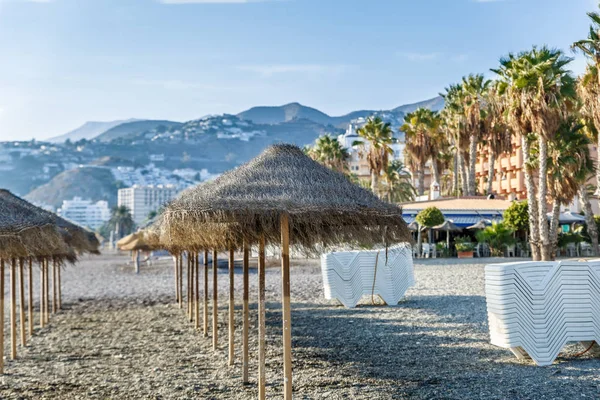 Vista de sombrillas, tumbonas y palmeras en una playa, España —  Fotos de Stock