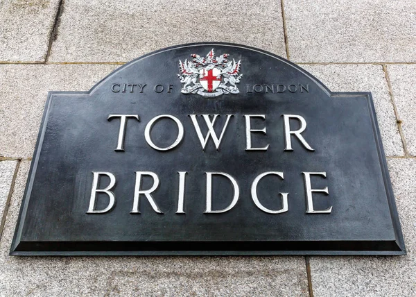 Tower Bridge sign on stone wall, London