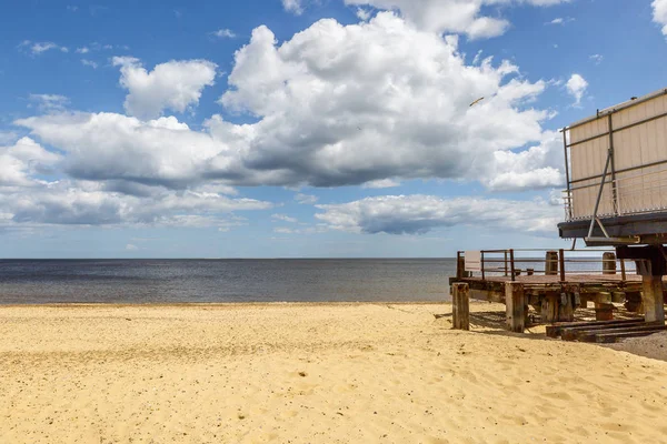 Θέα σε μια όμορφη παραλία μια ηλιόλουστη καλοκαιρινή μέρα ξύλινη προβλήτα — Φωτογραφία Αρχείου