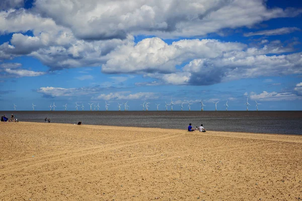 Eine kleine Gruppe von Leuten genießt einen sonnigen Tag an einem ruhigen Strand in — Stockfoto