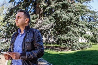 Onun elinde bir cep telefonu olan bir adam takdir manzara modunda 