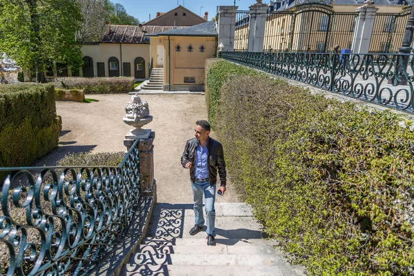 Um homem de jaqueta de couro e jeans está andando em um belo parque — Fotografia de Stock