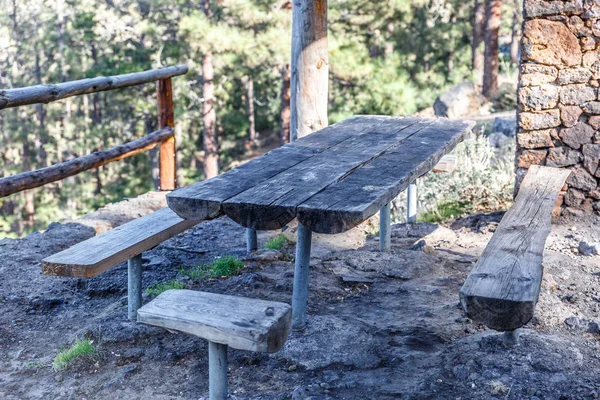 Tisch und Holzbänke in einer Hütte im Freien, wo man sich ausruhen und — Stockfoto