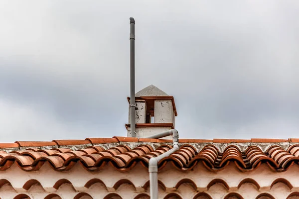 Білий димар на типовому оранжевому даху плитки — стокове фото