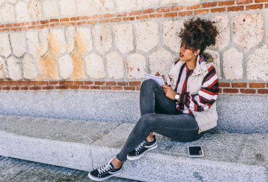 Taş bir bankta oturan güzel esmer kız, soğuk bir günde defterine yazdığı gibi düşünür.