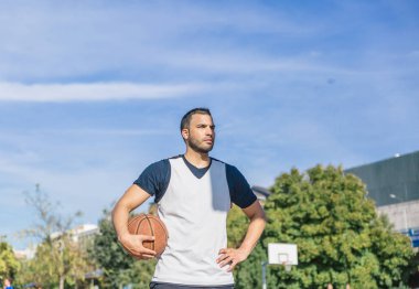 Sahadaki basketbol oyuncusu topuyla poz veriyor.