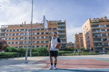 Açık hava sahasında güçlü bir basketbol oyuncusunun tüm vücut görüntüsü