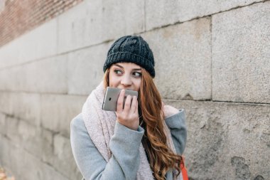 Caucasian blond girl carrying shopping bags, goes talking with h