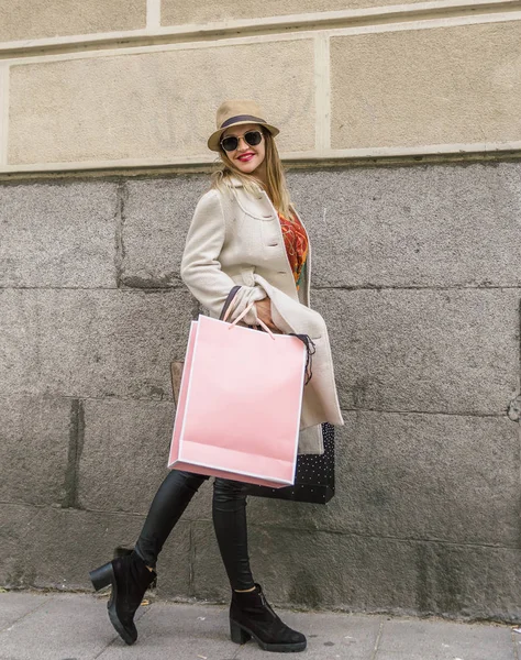 Привлекательная женщина с большим стилем носит розовую сумку во время прогулки по городской улице — стоковое фото