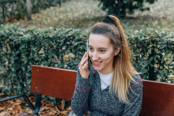 Happy Athlète Femme Sourit Parler Téléphone Mobile Assis Sur Banc — Photo
