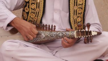 ISLAMABAD, PAKISTAN - 25 Aralık 2016 - Pakistan 'ın İslamabad kentinde düzenlenen Yıllık Şafak Medya Festivali öncesinde enstrümanı akort eden geleneksel Rubab çalıcısı.