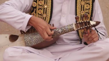 ISLAMABAD, PAKISTAN - 25 Aralık 2016 - Pakistan 'ın İslamabad kentinde düzenlenen Yıllık Şafak Medya Festivali öncesinde enstrümanı akort eden geleneksel Rubab çalıcısı.