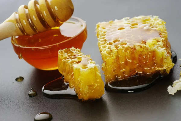 Honing en honingraat op een zwarte achtergrond — Stockfoto