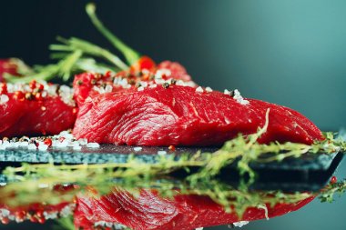 Yakın çekim taze sığır eti biftek ile karanlık bir arka plan üzerine baharat için