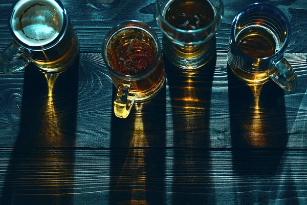 暗い木製のテーブルでビールを上から見るメガネ. — ストック写真