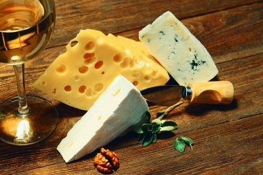 Peynir ve şarap bir bardak bir ahşap tahta üzerinde.