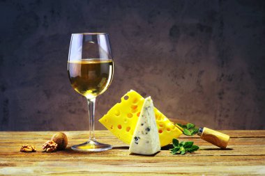 Peynir ve şarap bir bardak bir ahşap tahta üzerinde.