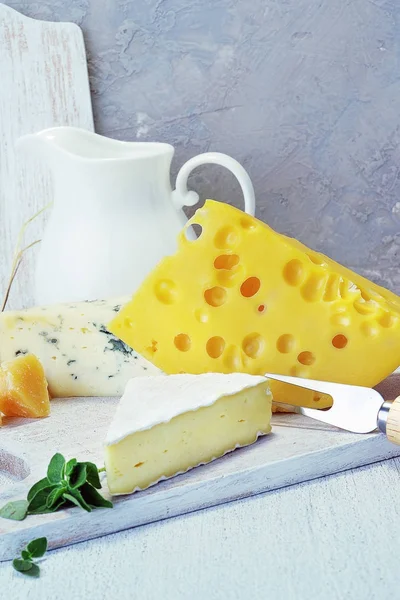 Käse und Milch auf einem alten Brett. Rustikaler Blick. — Stockfoto