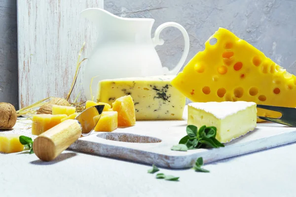 Käse und Milch auf einem alten Brett. Rustikaler Blick. — Stockfoto