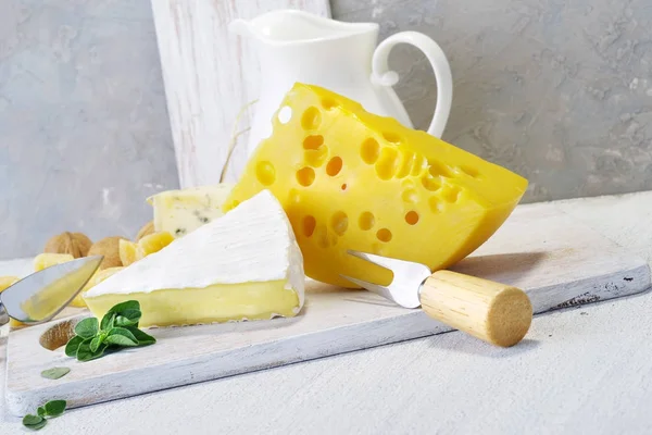 Käse und Milch auf einem alten Brett. Rustikaler Blick. — Stockfoto