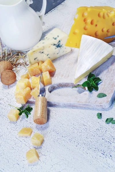 Käse und Milch auf einem alten Brett. Rustikaler Blick. — Stockfoto