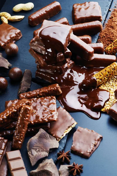 Uma variedade de produtos de chocolate em um fundo escuro . — Fotografia de Stock