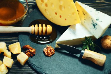 Peynir ve bal karanlık bir arka plan üzerinde.