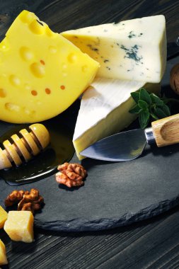Peynir ve bal karanlık bir arka plan üzerinde.