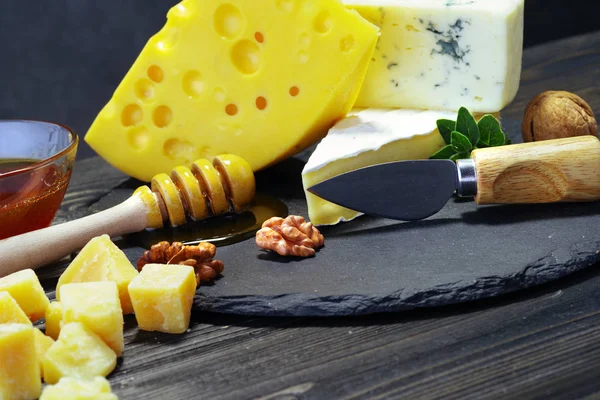 Käse und Honig auf dunklem Hintergrund. Nahaufnahme. — Stockfoto