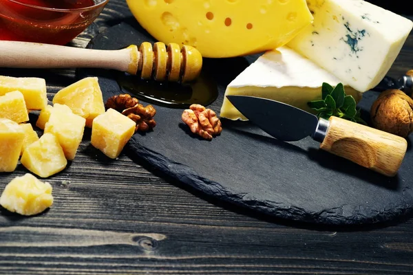Kaas en honing op een donkere achtergrond. Close-up. — Stockfoto