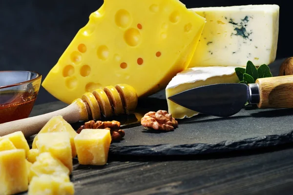 Käse und Honig auf dunklem Hintergrund. Nahaufnahme. — Stockfoto