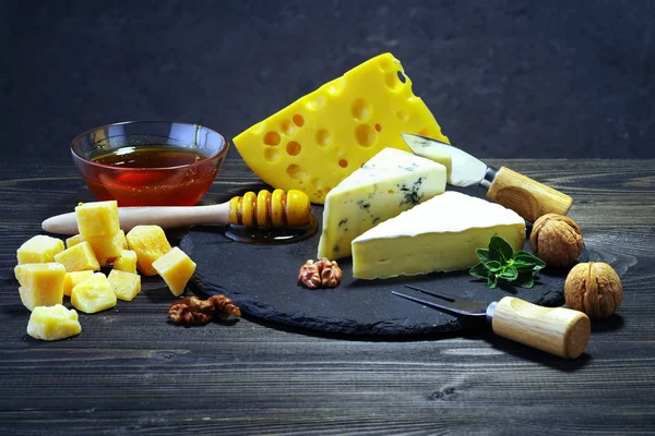 Käse und Honig auf dunklem Hintergrund. — Stockfoto