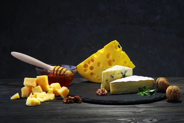 Käse und Honig auf dunklem Hintergrund. — Stockfoto