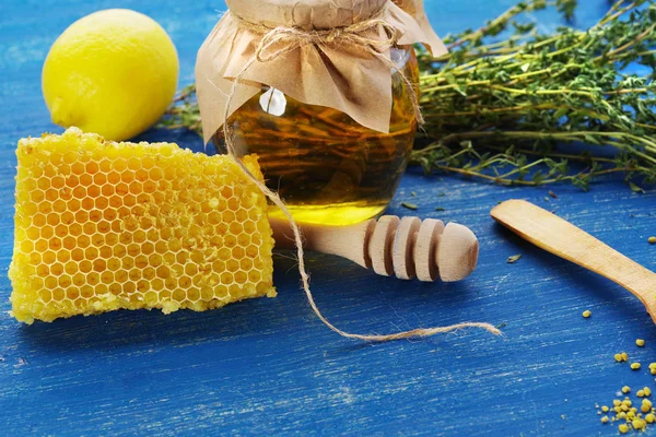 Honing met citroen en kruiden op een oude blauwe bord. — Stockfoto