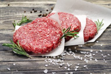 Ahşap bir masa burgers için taze çiğ kıyılmış et.