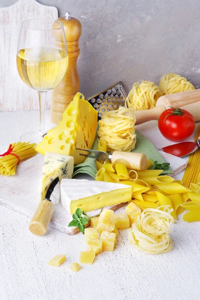 Pasta und Käse mit verschiedenen Zutaten zum Kochen auf rustikalem Hintergrund. — Stockfoto