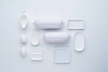 Üstten Görünüm kompozisyon beyaz yemekler ve sosis az ve öz bir tarzda. Düz yatıyordu.