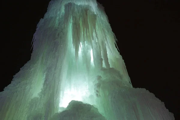 Ice waterfall, texture of ice, a frozen fountain cascades of icicles, frozen ice fountain, ice sculpture, glowing ice, christmas, new year, background Royalty Free Stock Images