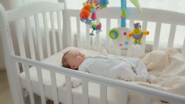 Şirin Bebek beşiğine iplik oyuncak atlıkarınca ile yalan