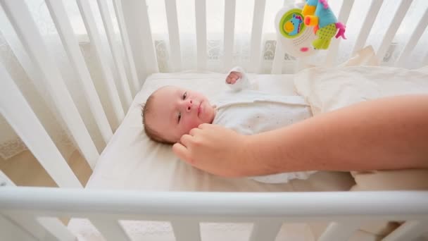 Nahaufnahme von Elternhand streichelt Baby, das im Bett liegt und beruhigt — Stockvideo