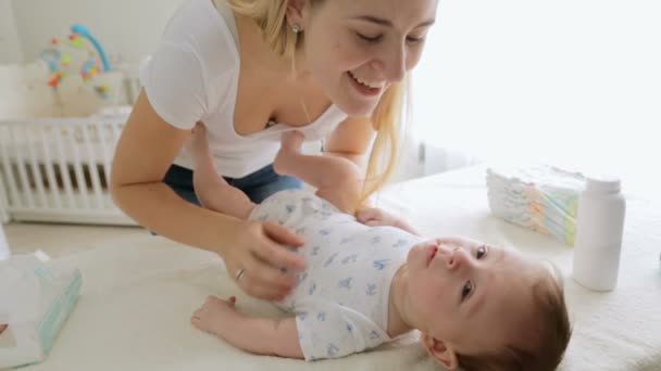 Close-up van jonge vrolijke moeder haar jongen baby praten en spelen met hem — Stockvideo