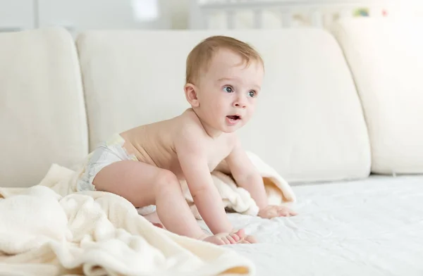 Bebé niño en pañales cubiertos de toalla después de bañarse arrastrándose en b — Foto de Stock