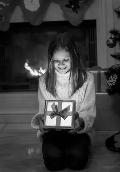 Χαμογελαστό κορίτσι ψάχνει μέσα από το λαμπερό παρόν με Χριστούγεννα pr — Φωτογραφία Αρχείου